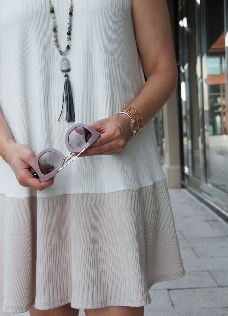 gray tassel necklace and pink sunglasses