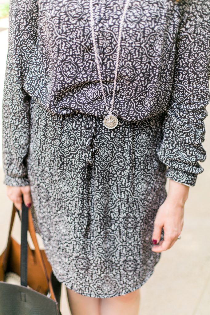 black and white print work dress with long silver pendant necklace