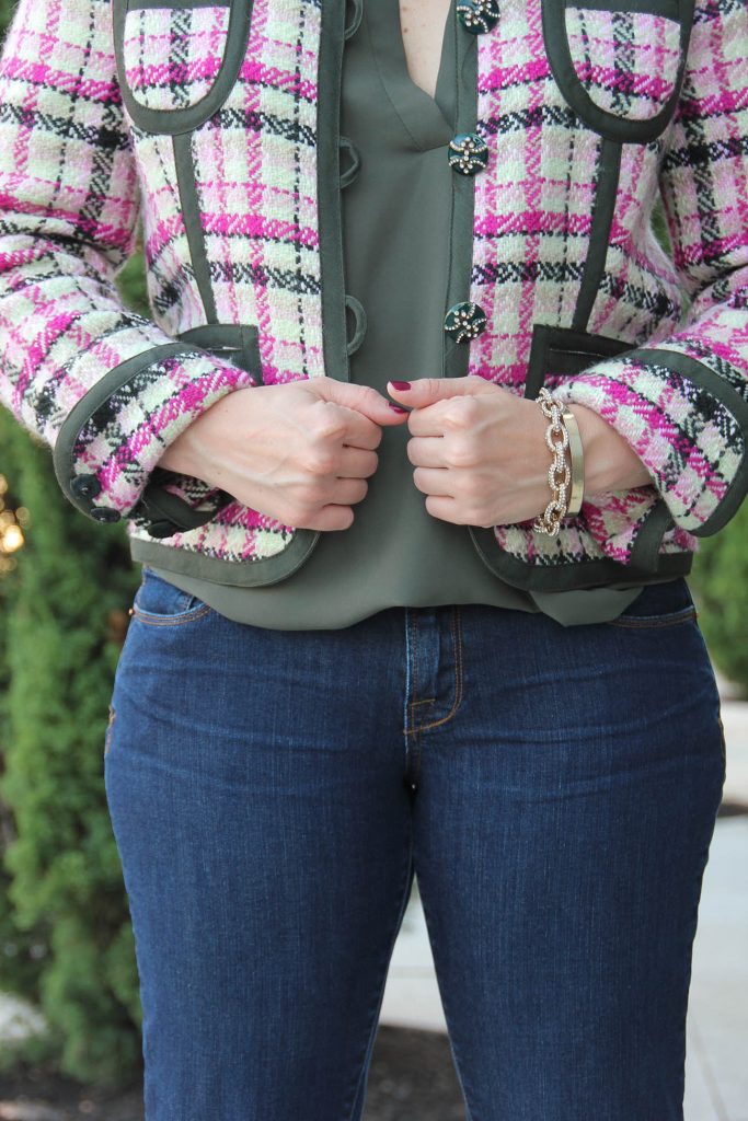 A vintage pink and olive tweed jacket with gold bracelets.