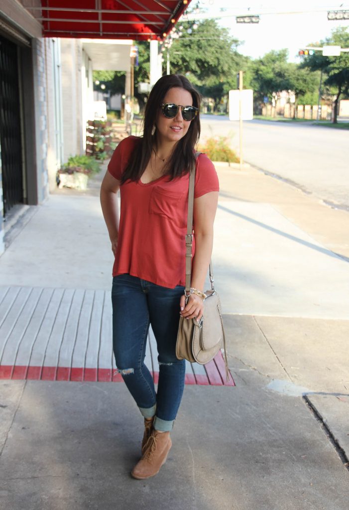Houston Fashion Blogger in a casual weekend outfit featuring a orange tshirt, distressed jeans, and tan booties.