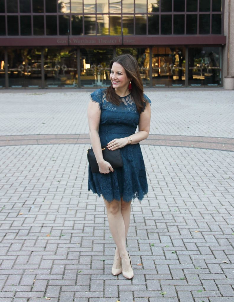 Houston Fashion blogger wears a holiday party outfit featuring a teal lace dress and red tassel earrings.