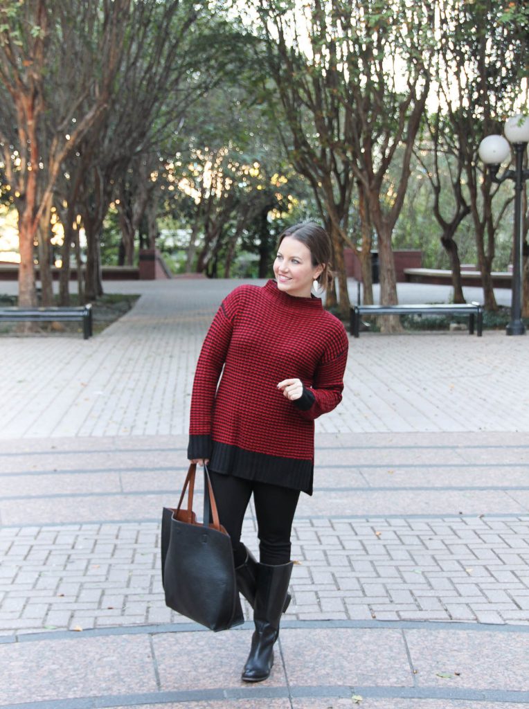 Houston Fashion Blogger wears a winter outfit idea featuring a red sweater, black jeans and riding boots.