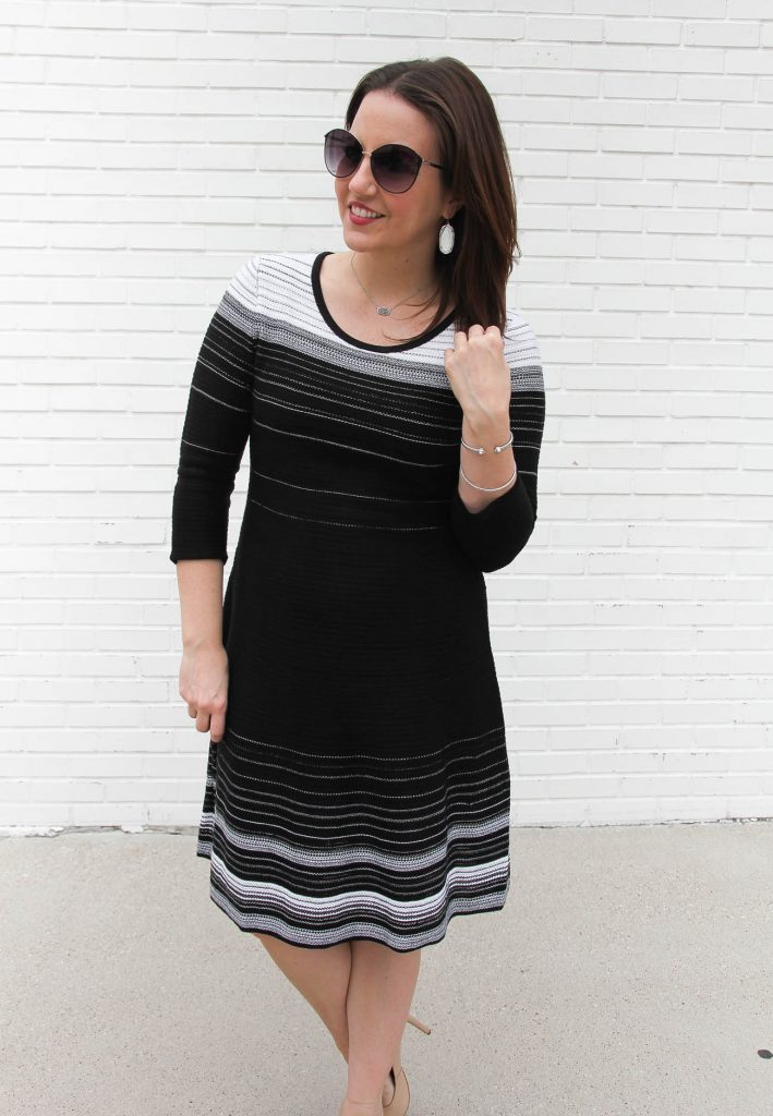 Lady in Violet wears a fit and flare black sweater dress.