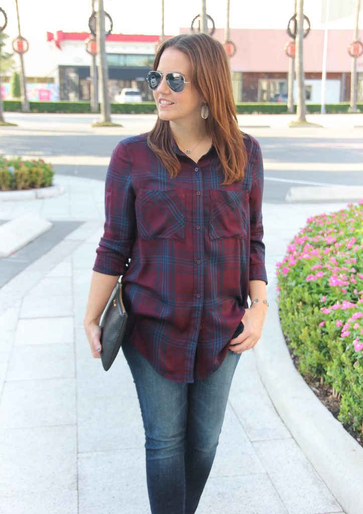 Houston Fashion Blogger wears a fall outfit featuring a burgundy and navy plaid tunic.