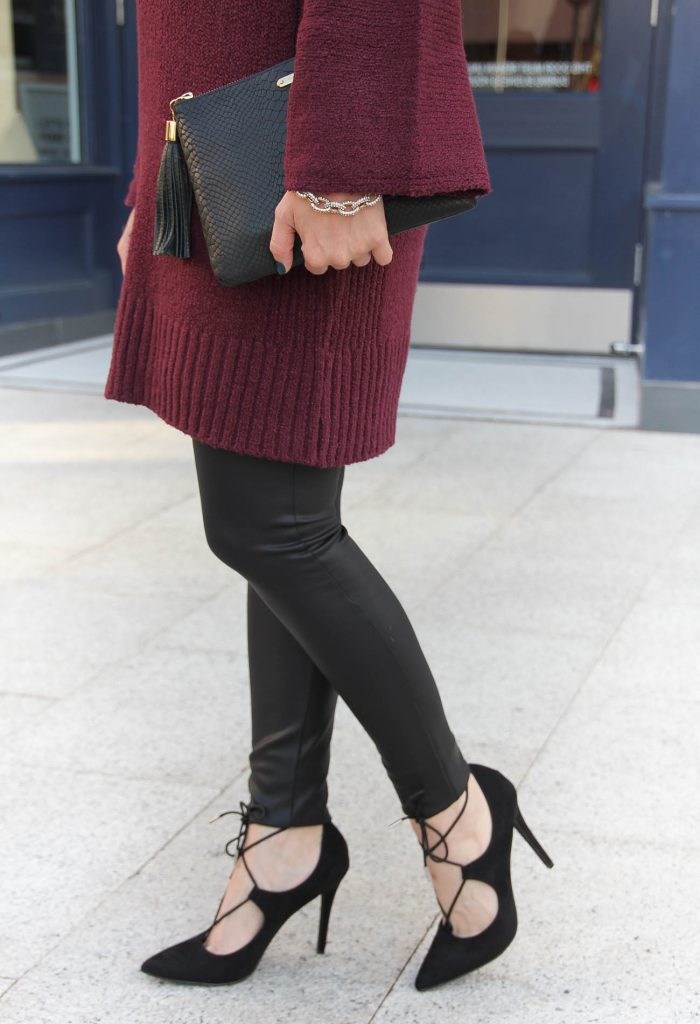 Trendy woman in an oversized grey sweater and black leather leggings