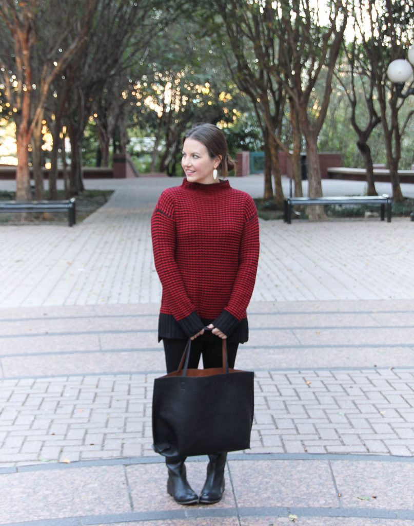 Houston Fashion Blogger, Lady in Violet wears a red Christmas sweater outfit with jeans, boots and a tote bag.