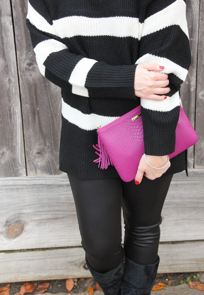 Lady in Violet, Houston fashion blogger styles a winter party outfit featuring leather leggings, a pink clutch, and a striped sweater.