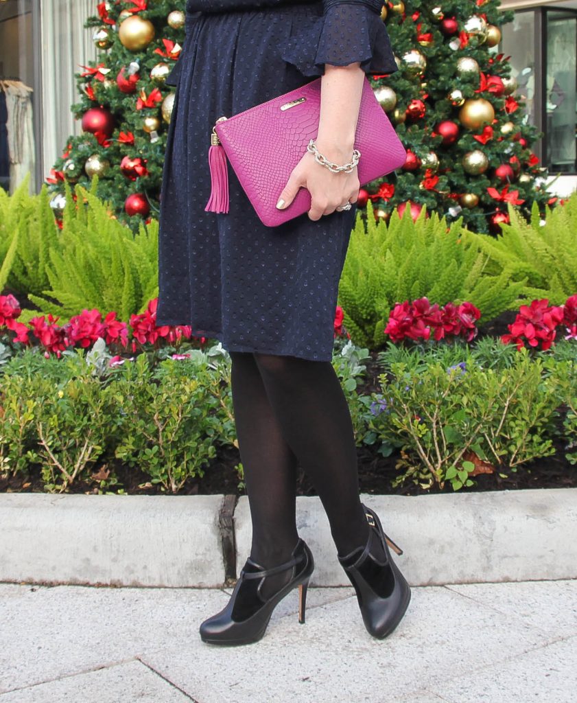 Houston style blogger wears a Christmas morning church dress idea featuring a navy dress, black tights and black heels.