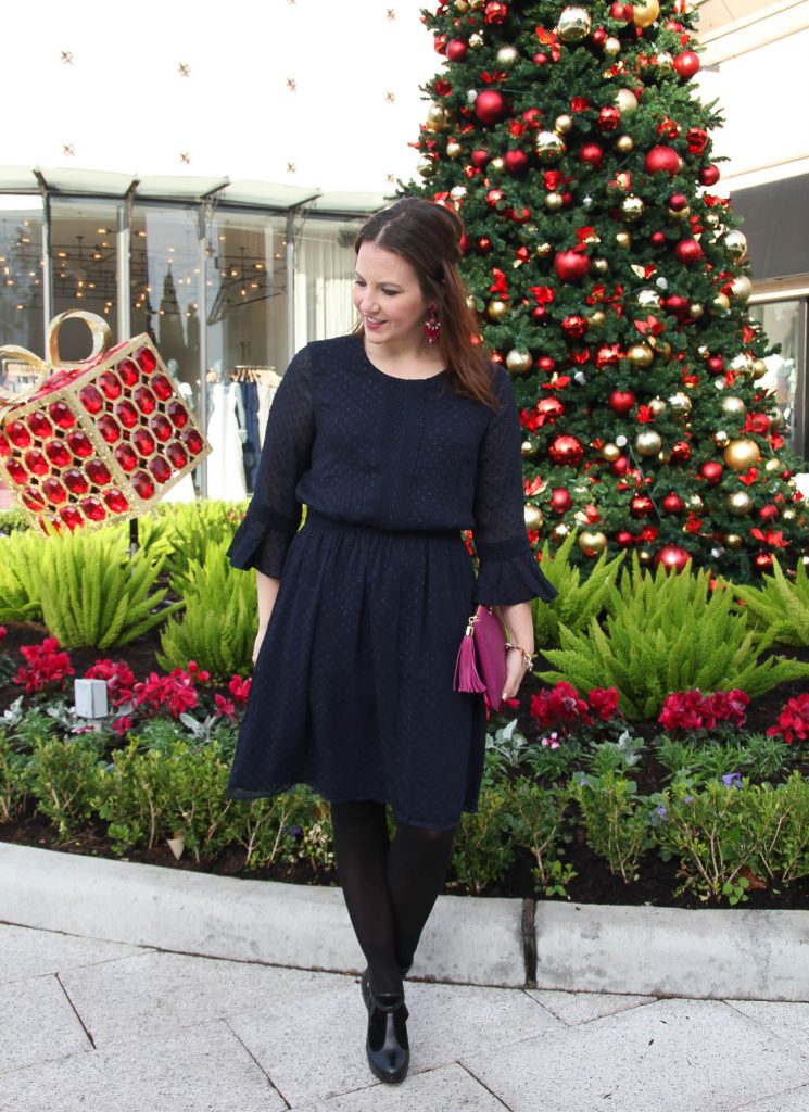 Lady in Violet, Houston Style Blogger styles a Christmas morning dress for church featuring a navy ruffle sleeve dress with black tights and black dress booties.