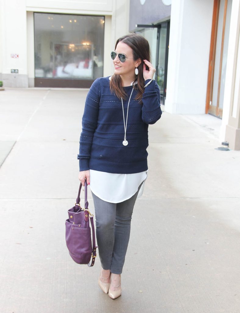 Houston Fashion Blogger styles a winter layered outfit featuring a navy sweater, white tunic, and gray jeans. Click through for outfit details.