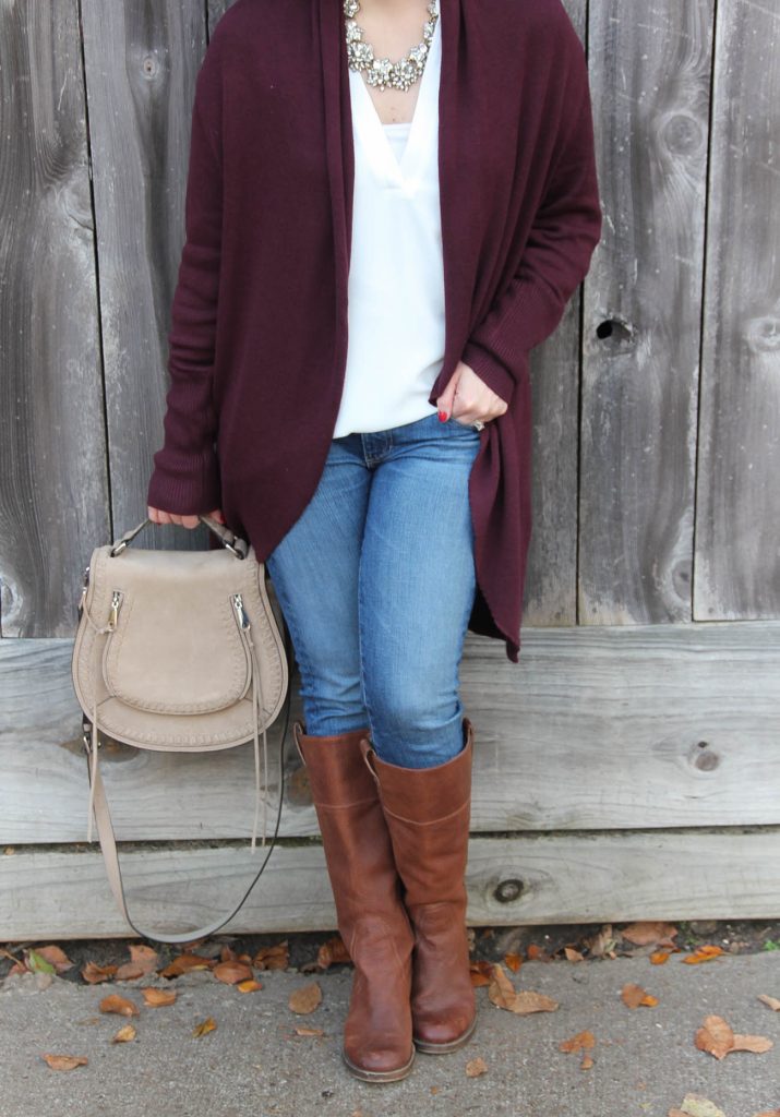 Karen Rock of Lady in Violet styles a casual fall outfit featuring a long cardigan, riding boots, and a saddle bag purse.