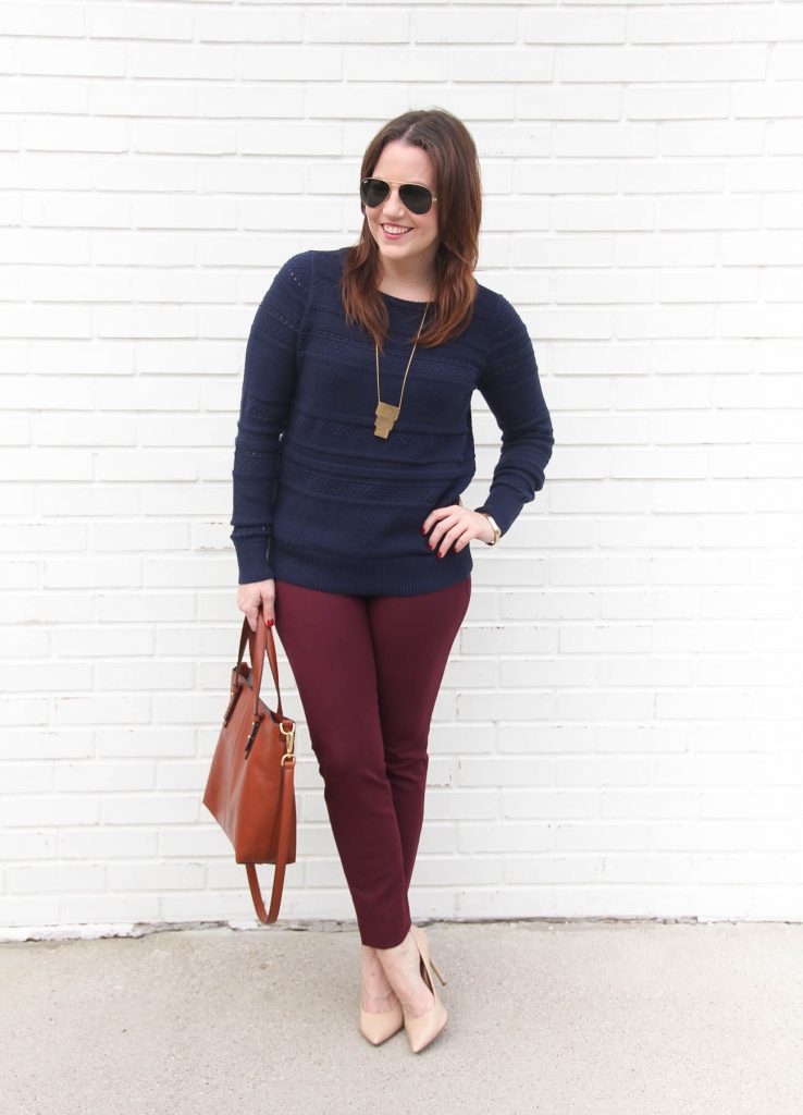 Houston fashion blogger Lady in Violet styles a sophisticated winter work outfit idea featuring a navy sweater and maroon pants.