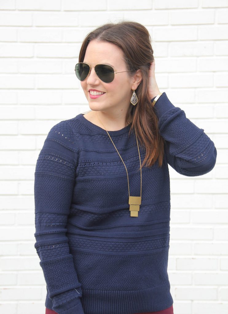 Karen Rock of Lady in Violet wears a Loft work outfit featuring a navy sweater and gold long pendant necklace.