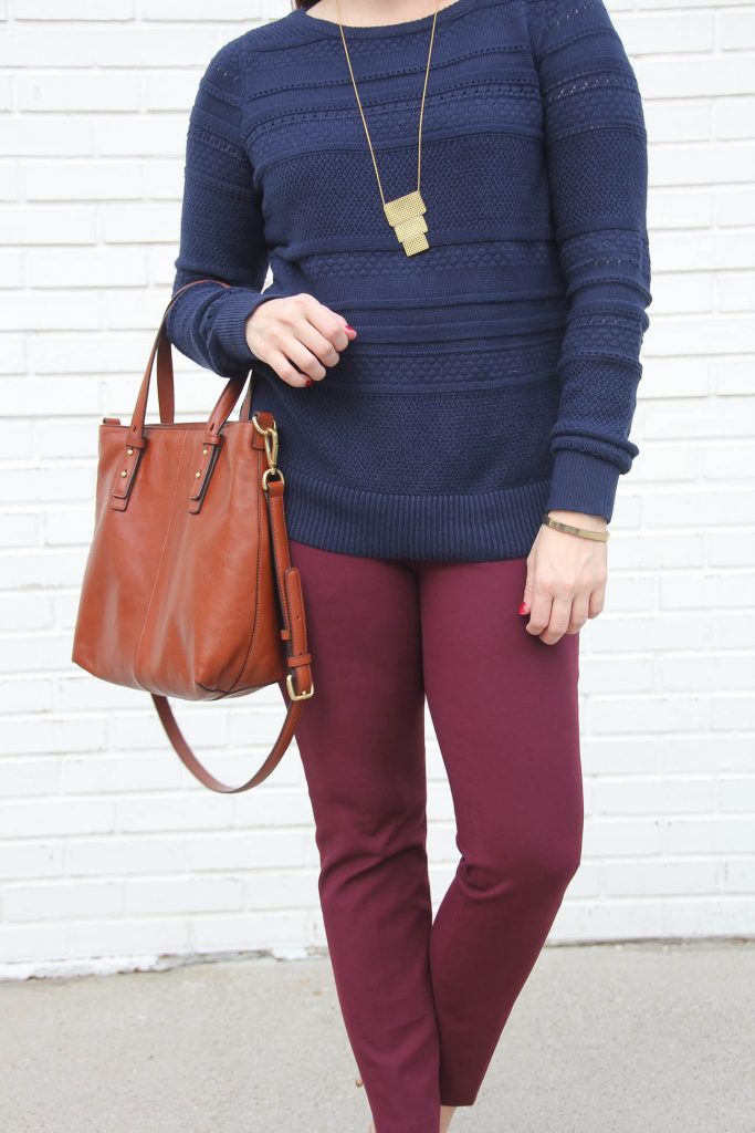 Houston Style Blogger Lady in Violet styles a chic color mixing work outfit idea featuring a navy sweater and burgundy pants with a brown tote bag.