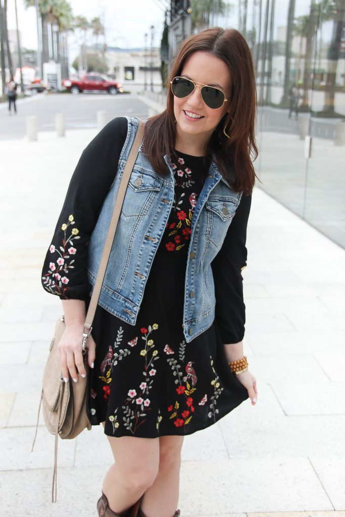 Lady in Violet, a Houston based fashion blogger styles a rodeo outfit idea featuring a denim vest and embroidered dress.