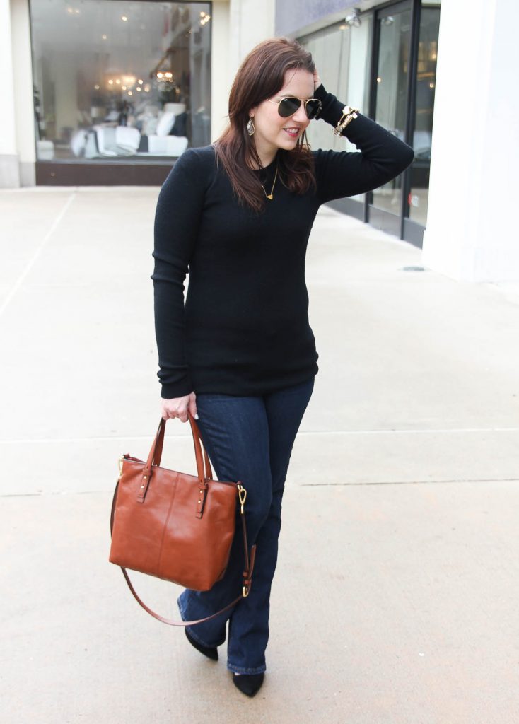 Karen Rock, a Houston based fashion blogger wears a casual winter outfit including a black fitted sweater and bootcut jeans with heels.