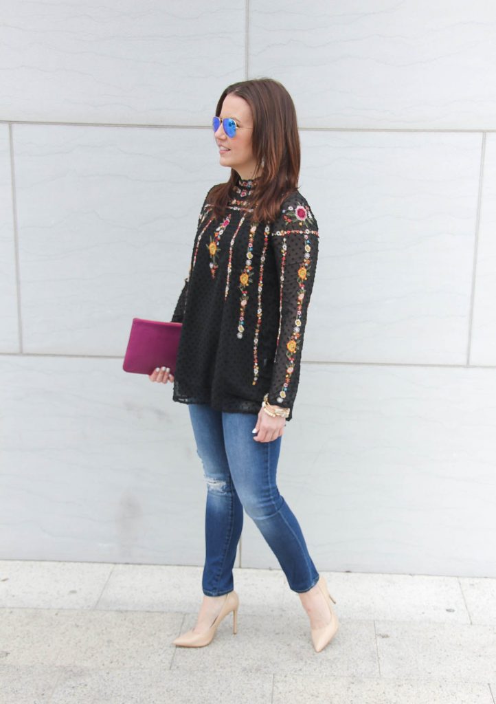 Karen Rock, a Houston Fashion Blogger styles a date night outfit idea including a floral embroidered top with distressed jeans and nude heels.