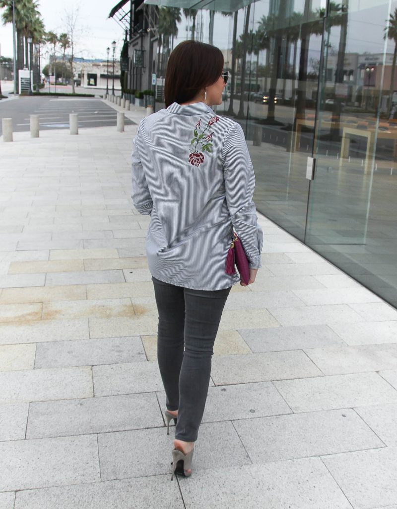 Karen Rock, a Houston based personal style blogger, wears a striped rose embroidered blouse with gray skinny jeans for date night.