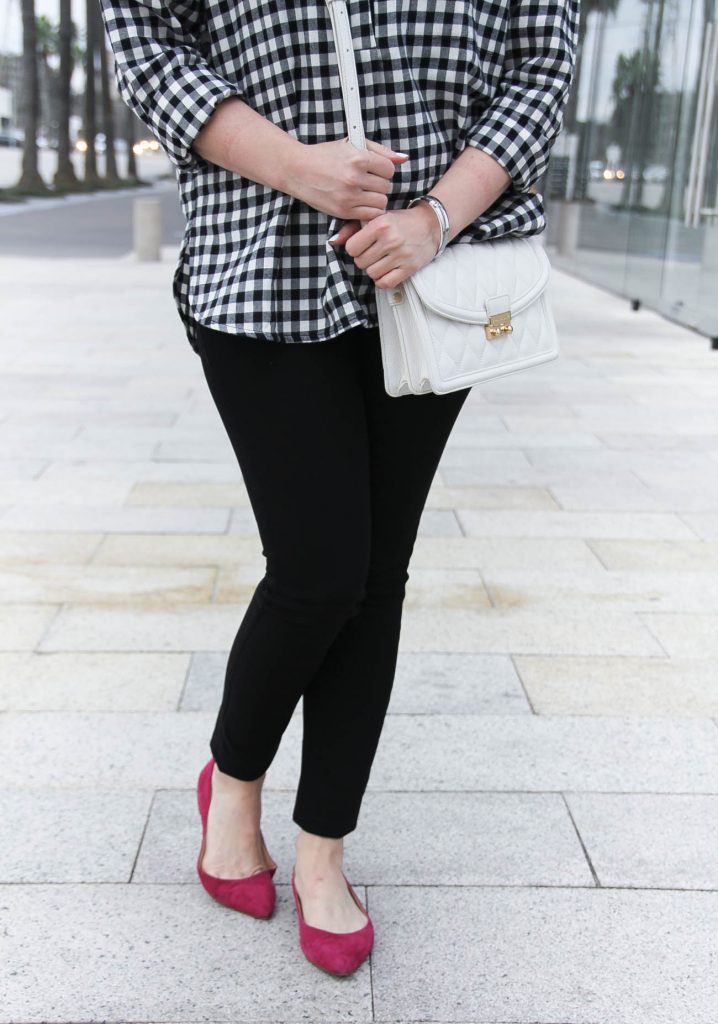 Lady in Violet wears DL1961 black skinny jeans with pink flats and a white crossbody bag.