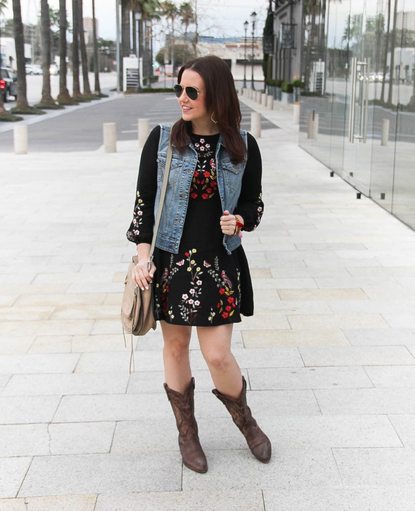 Lady in Violet, houston fashion blogger styles a rodeo outfit idea including an embroidered dress, denim vest, and cowboy boots.