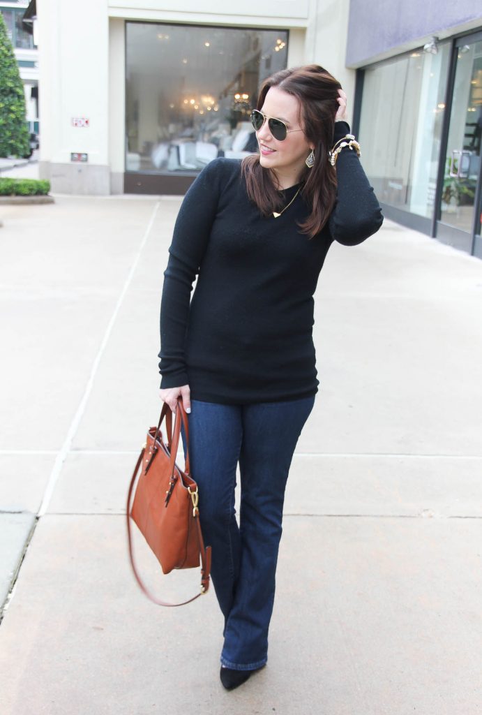 Karen Rock the Houston fashion blogger behind Lady in Violet wears a casual Friday office outfit for winter including a black sweater, flared jeans and lace up heels.