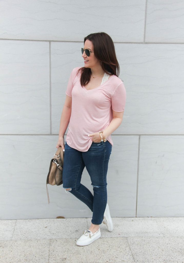 Houston fashion blogger styles a comfy travel outfit for a road trip including a pink tee, distressed jeans, and white sperry shoes.