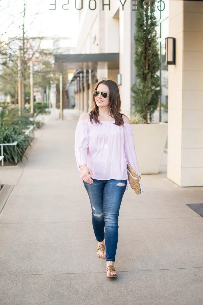 Lady in Violet, a Houston based fashion blogger, wears a pink cold shoulder top with distressed jeans and tory burch sandals for spring outfit inspiration.