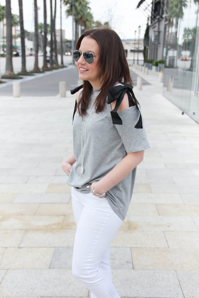 Lady in Violet, a Houston fashion blogger wears a cold shoulder bow tee and white jeans.