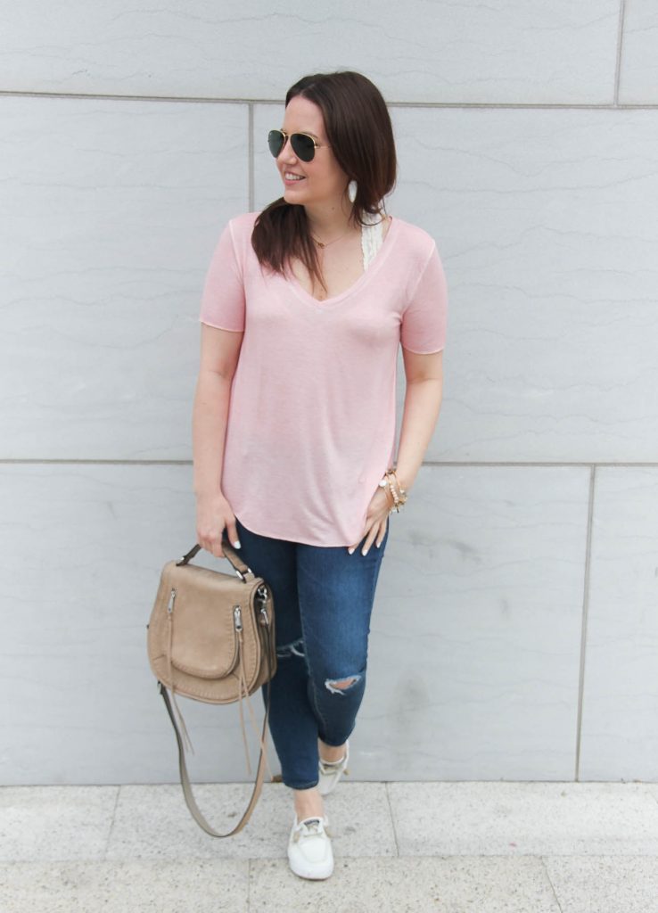 Houston fashion blogger, Lady in Violet, styles a comfy road trip outfit featuring a pink tee, skinny jeans, and white sneakers.