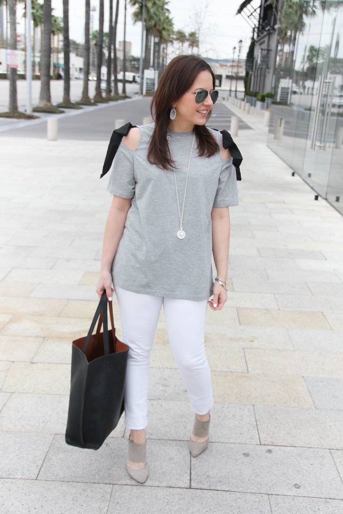 Lady in Violet styles a spring casual outfit including a gray cold shoulder tee, white skinny jeans, and gray suede heels.