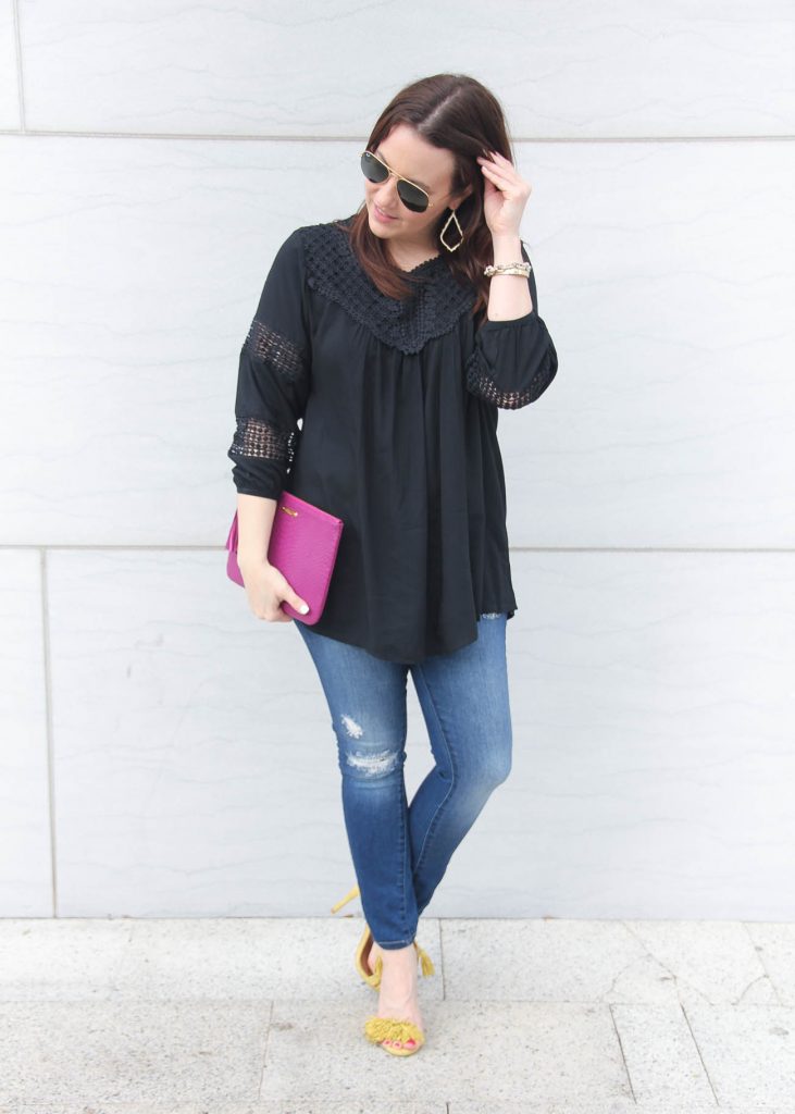 Houston fashion blogger wears a spring outfit idea featuring distressed jeans, black flowy top and yellow sandals.