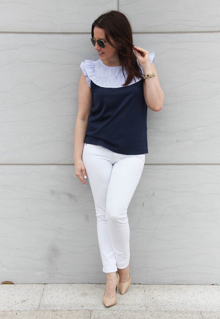 Spring outfit including white jeans, nude heels, and a navy sleeveless top.