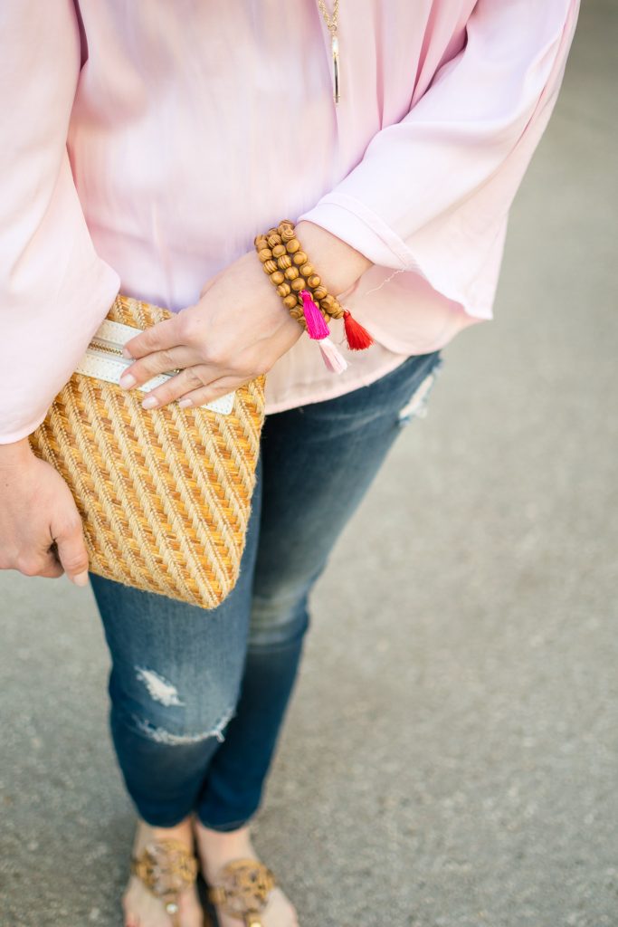 Spring accessories including tassel bracelets and a straw clutch with white tassels.