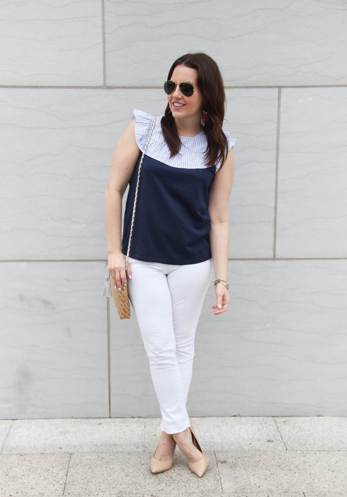 Lady in Violet styles a summer outfit including white jeans and a navy ruffle tee with heels.