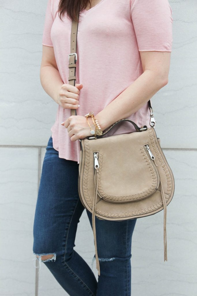 Houston fashion blogger styles casual summer outfit inspiration including a pink tshirt, jeans, and a chloe saddle bag dupe.