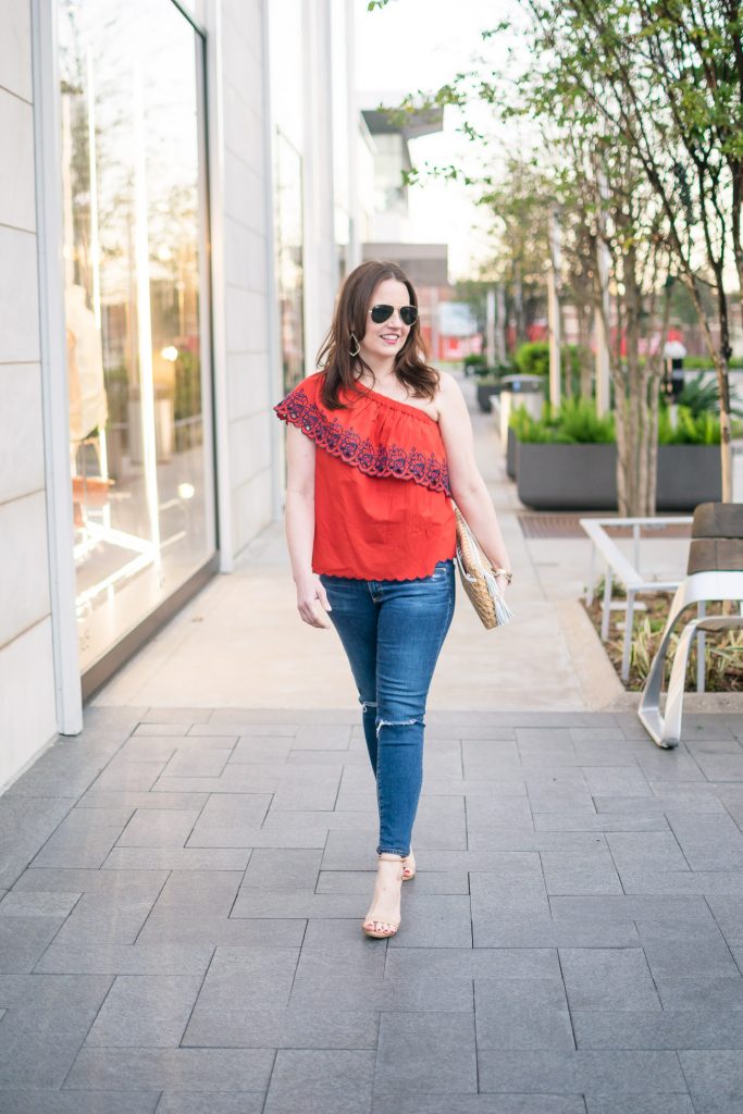 Houston fashion blogger styles spring outfit ideas with a one shoulder top and distressed jeans.