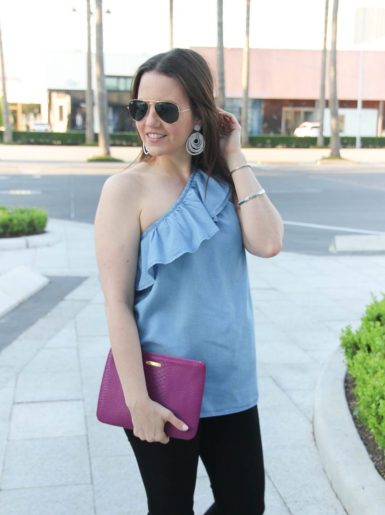 Karen Rock, a Houston fashion blogger wears chambray ruffle one shoulder top with white statement earrings.