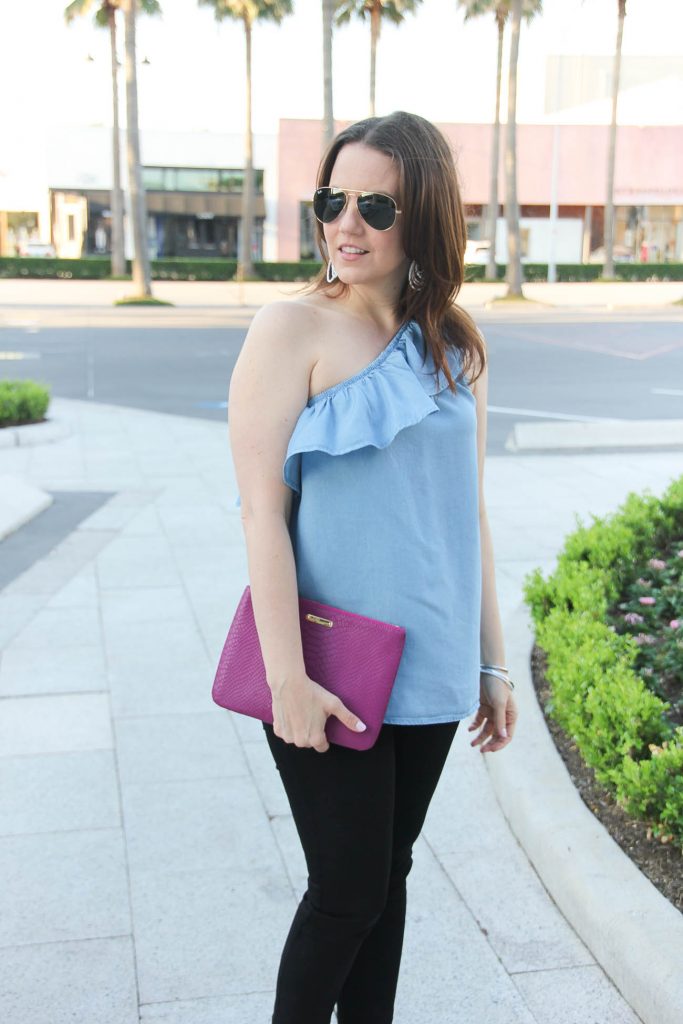 Houston Style Blogger wears girls night out outfit including one shoulder top with black skinny jeans and a pink clutch.