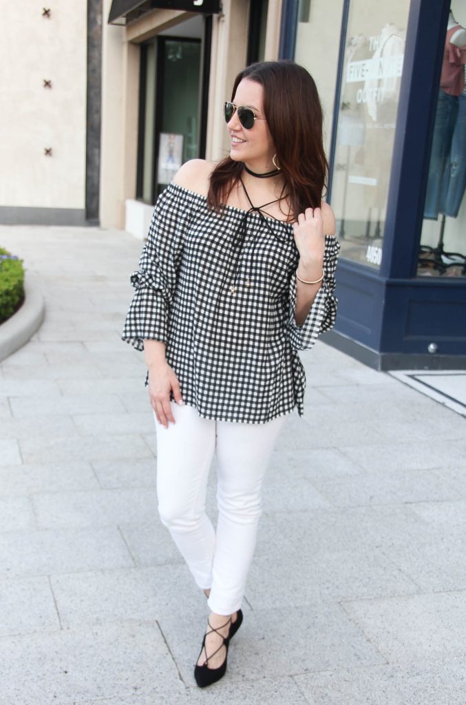 Houston fashion blogger wears spring outfit ideas including gingham off the shoulder top with bell sleeves and white denim with black heels and a choker necklace.