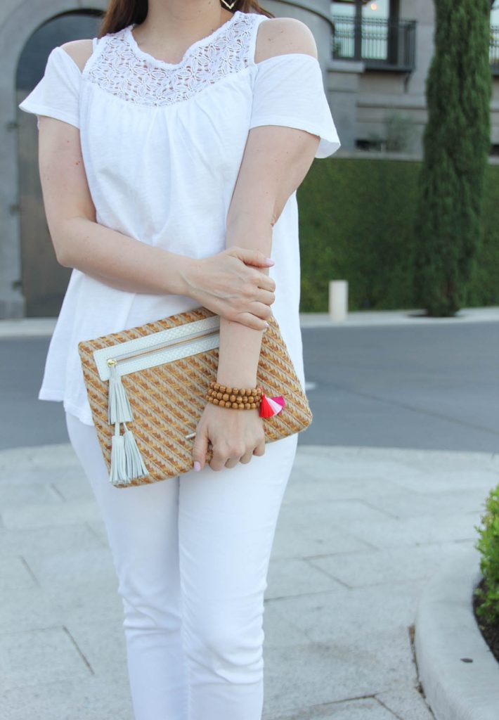 Lady in Violet, a Houston fashion blogger, wears a cold shoulder top with the Elaine Turner Sonata bag and pink tassel bracelets.