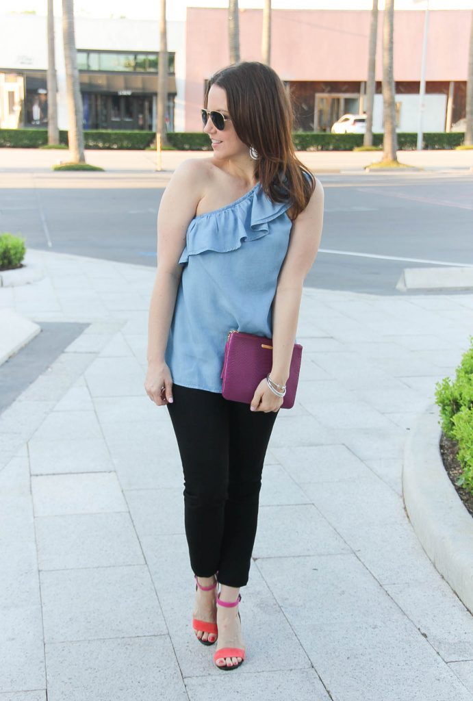 Houston blogger Lady in Violet styles spring outfit including chambray one shoulder top with black jeans and block heel sandals.