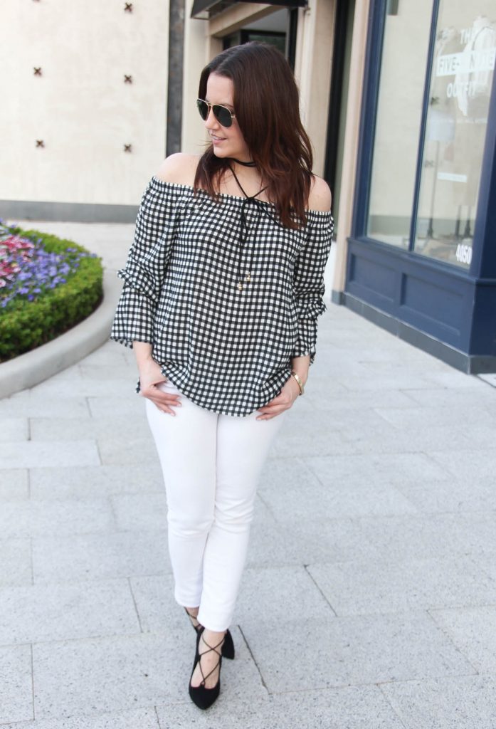 Houston fashion blogger styles a spring outfit idea including gingham bell sleeve top with white jeans and black lace up heels.