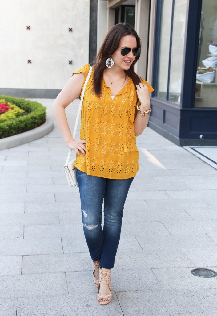 Houston fashion blogger Lady in Violet wears casual weekend outfit including yellow top with distressed jeans and wedge sandals.