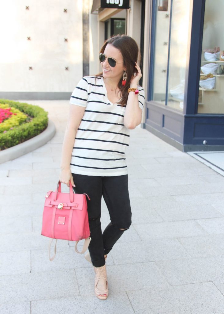 Houston style blogger wears casual spring outfit idea including striped tee, black skinny jeans, wedges, and pink backpack.