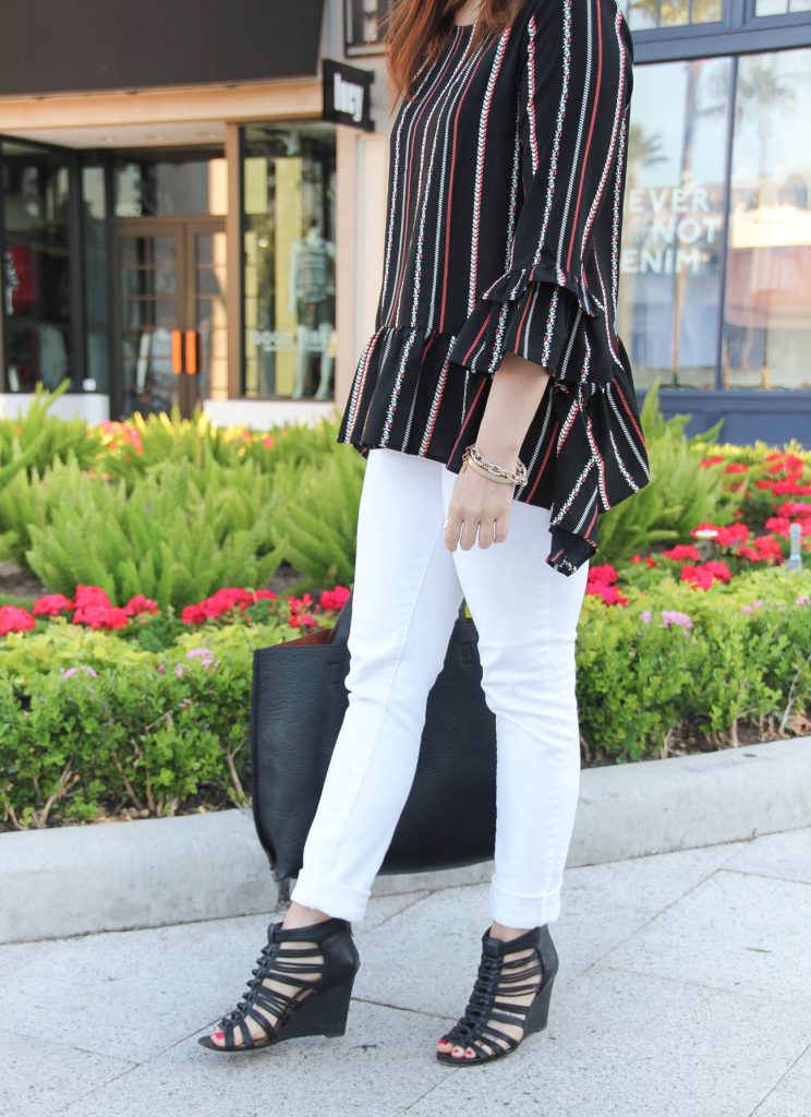 Houston fashion blogger styles spring outfit inspiration including white jeans, black wedge sandals, and peplum blouse.