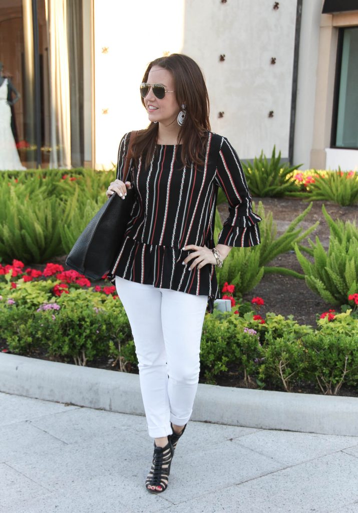 spring outfit including peplum top, white skinny jeans, and affordable black tote bag