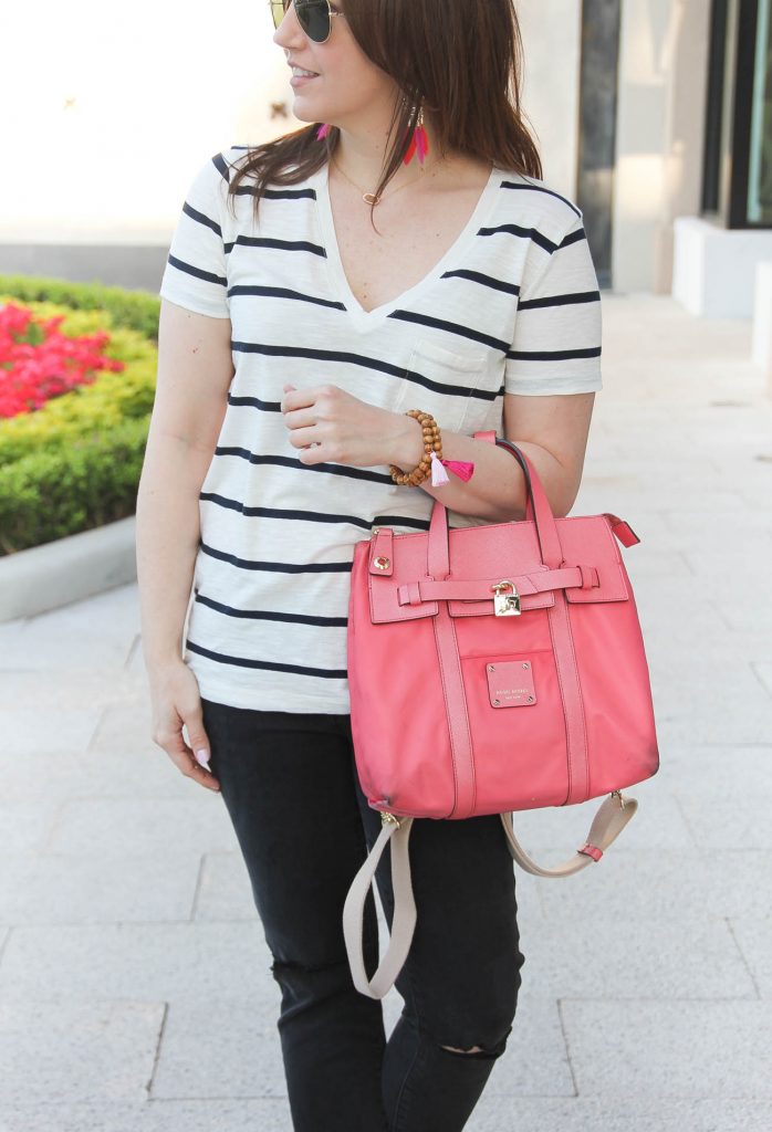 Houston blogger wears casual striped tee and distressed jeans with pink purse.