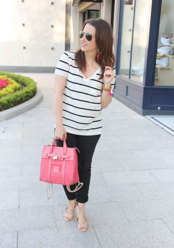 Houston fashion blogger styles casual outfit inspiration including striped tee with black jeans and nude wedges paired with pink bag.