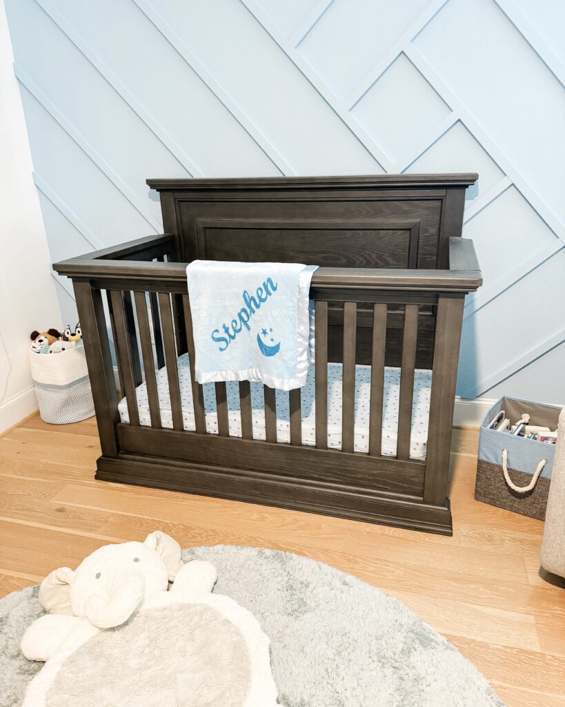 brown baby crib | blue statement wall for babys room | Texas Mom Influencer Lady in Violet